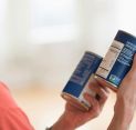 Woman examining food cans with Non-GMO label